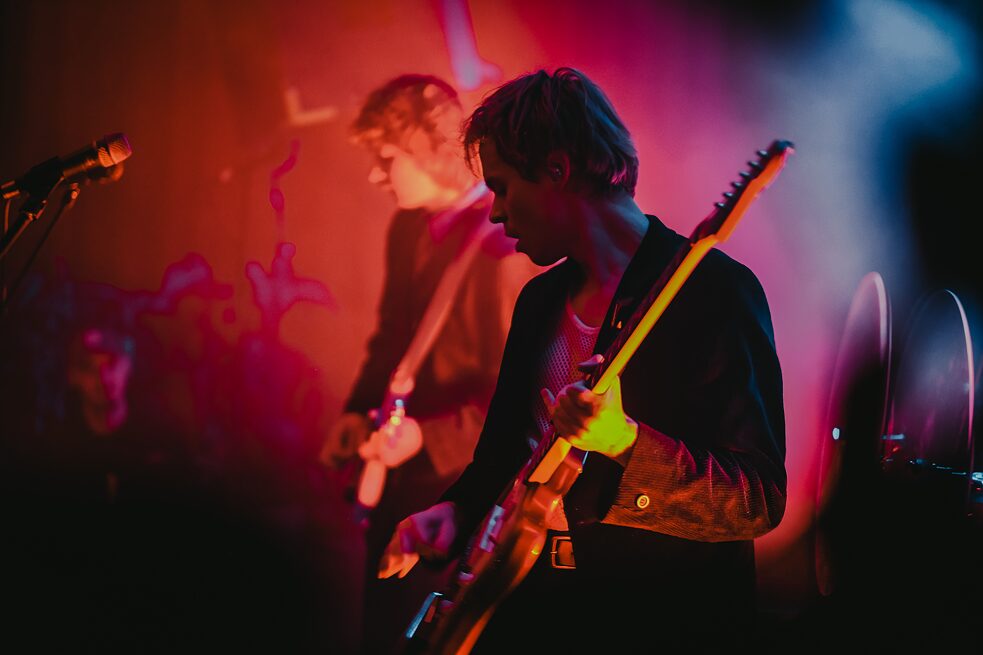 Ein junger Musiker, der ein Rockkonzert auf der Bühne gibt.