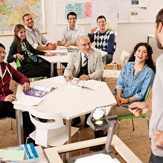 L'étudiant montre le tableau blanc et parle à l'enseignant