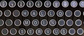 Auf einer Schreibmaschinentastatur stehen die Wörter Hallo, Moin und Servus. 