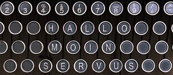 The words Hallo, Moin and Servus on a typewriter keyboard