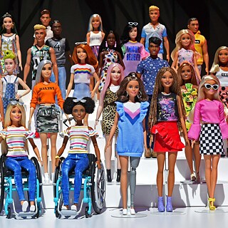 Πολλές διαφορετικές κούκλες Barbie μπροστά σε μαύρο φόντο