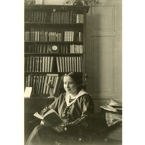 חנה ארנדט בצעירותה (גיל לא ידוע), יושבת בספרייה המשפחתית. תאריך לא ידוע.  