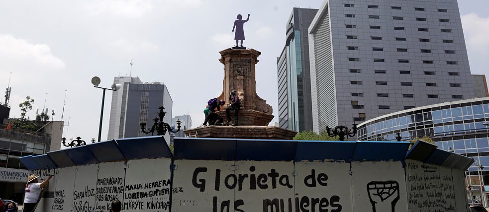 Um grupo de mulheres pinta a cerca que protege o lugar onde esteve a estátua de Cristóvão Colombo na Cidade do México. Isso aconteceu depois que ativistas inauguraram, no dia 25 de setembro de 2021, uma “antimonumenta”em homenagem às “mulheres que lutam”.