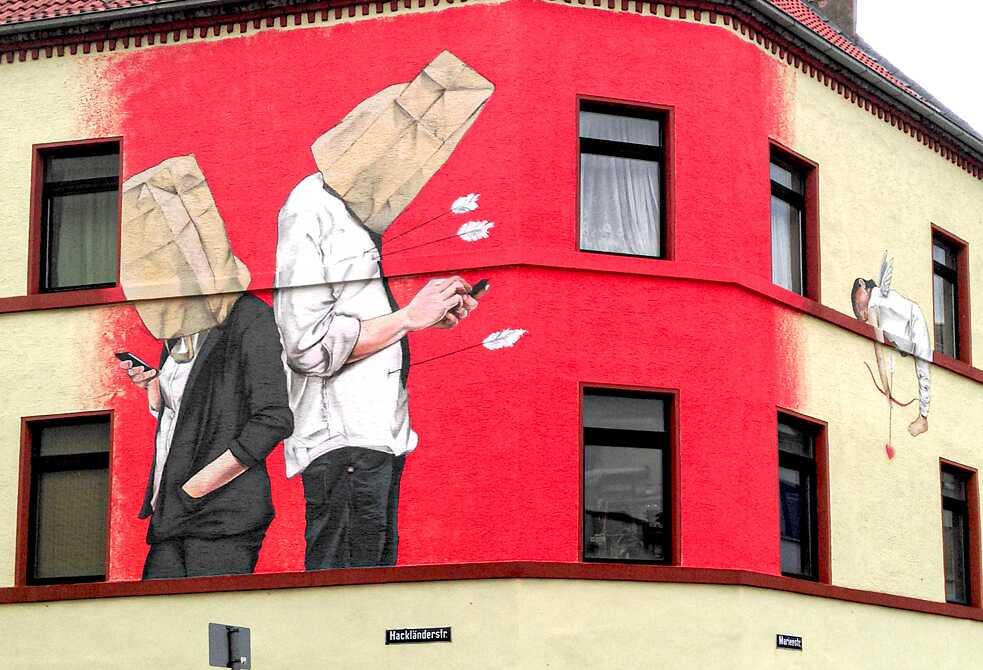 Christian Böhmer is from Bad Kreuznach in Rhineland Palatinate and not only has he been a graffiti artist since the early days of his youth, he has also now become a sought-after portrait painter. He is most famous for his “paper bag heads”, with which he questions the digitalised world from the streets of Germany – including a building on the corner of Hackländerstraße 2 in Cologne. Artist: Christian Böhmer | Title: Unsuccessful Amor | Location: Hackländerstraße 2, Cologne