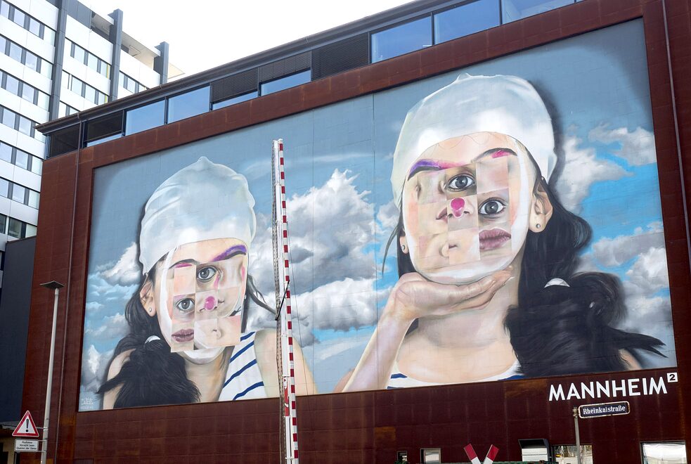Case Maclaim, whose real name is Andreas von Chrzanowski, grew up in Schmalkalden, and was probably involved to some extent in the colourful transformation of the small town. His motifs usually combine photo realism with surrealistic elements. One of his biggest projects in terms of cost is a mural covering 700 square metres on an old warehouse in Mannheim. The rectangular division of the faces is a play on the architecture in the “city of squares”. Further murals by Case Maclaim can be admired in Heidelberg, Berlin and Munich – and of course in Schmalkalden too. Artist: Case Maclaim | Title: Unknown | Where: Rheinvorlandstraße, Mannheim