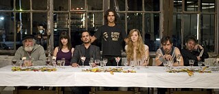 Am Esstisch sitzende Menschen