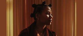 Ami Warning ist auf beigefarbenem Hintergrund im Seitenprofil zu sehen