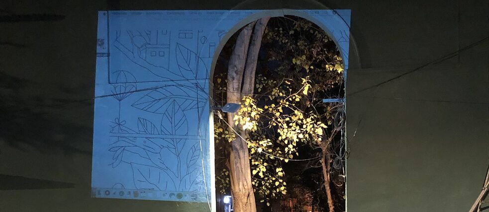 A digital sketch of the mural is projected onto the wall to create an outline.