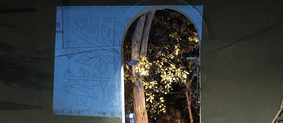 A digital sketch of the mural is projected onto the wall to create an outline.