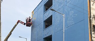 The first colour of the mural to appear on the wall is yellow.