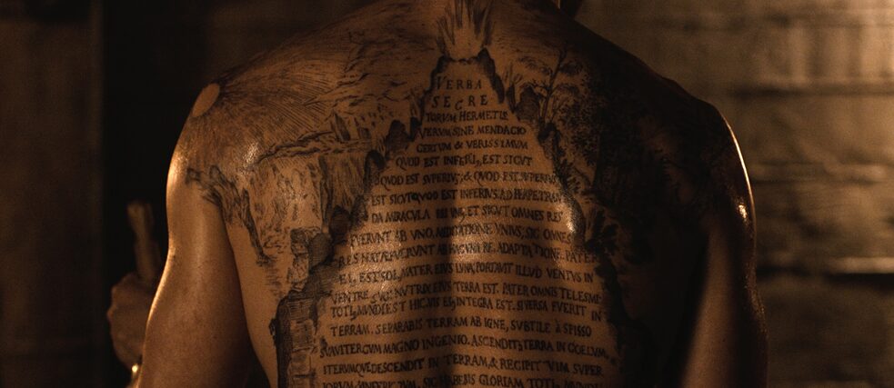 Ein Tattoo mit einer lateinischen Inschrift auf dem Rücken eines Mannes 
