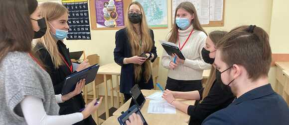 Schüler*innen und ihre Lehrkraft bei der Durchführung des Planspiels „Klimaneutrale Stadt“