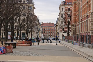 Jungs, die auf einem kleinen Platz neben der Karl-Liebknecht-Straße Basketball spielen
