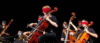 Strygere fra STEGREIF.orchester, som spiller med bind for øjnene.  &copy; © Navina Neuschl STEGREIF.orchester 