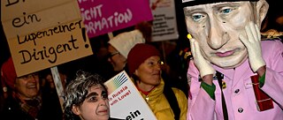 En demonstrant utklädd till Putin (h) står bredvid en demonstrant utklädd till Gergijev framför Philharmonie i München (Bayern) den 18/12 2013.