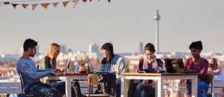 Sitzende Menschengruppe mit mobilen Endgeräten in Berlin
