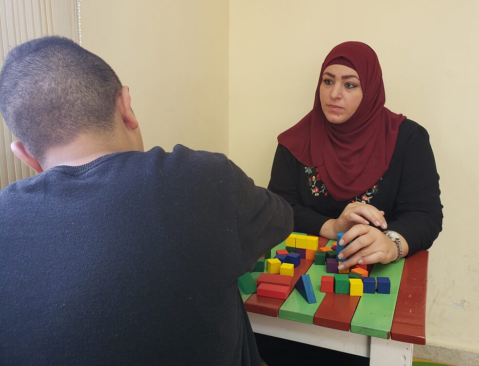 Patient Salam plays with psychology specialist and counselor Hanan Walid “the ladder and snake” game during a therapy session. 