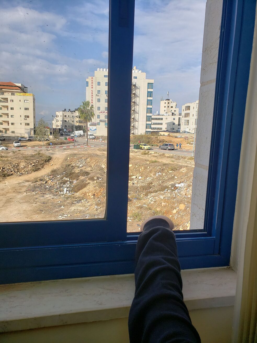L'enfant Salam regarde par la fenêtre de la pièce à Ramallah où se déroule sa séance de traitement avec la psychologue et conseillère Hanan Walid.