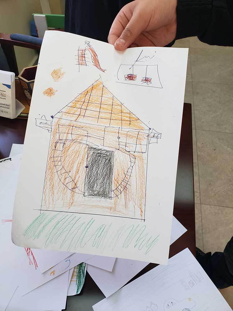 Patient Salam shows a picture he draw during a session with psychology specialist and counselor Hanan Walid. 