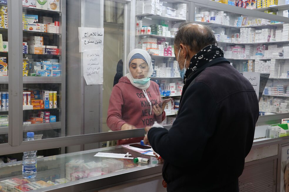 In einer Apotheke in Beirut wird ein Kunde von einer Apothekerin beraten. Viele Medikamente sind nicht mehr verfügbar. Die noch verfügbaren Medikamente sind für viele nicht erschwinglich, da alle Preise in US-Dollar sind.