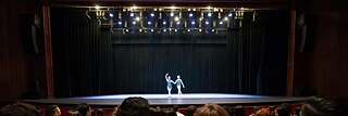 Zwei Tänzer auf einer Bühne, im Vordergund das Publikum