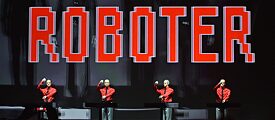 Robots de pie sobre el escenario durante un concierto de Kraftwerk en la Nueva Galería Nacional de Berlín en enero de 2015, creados ópticamente a semejanza de los miembros de la banda.