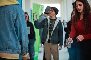 Trois élèves essaient de m'asperger avec une bombe aérosol.