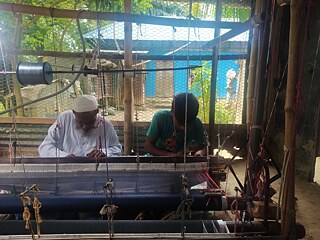 Elen Miah mit seinem Shagred (Lehrling) beim Weben von handgewebten Jamdani in seiner Fabrik, Narayanganj 