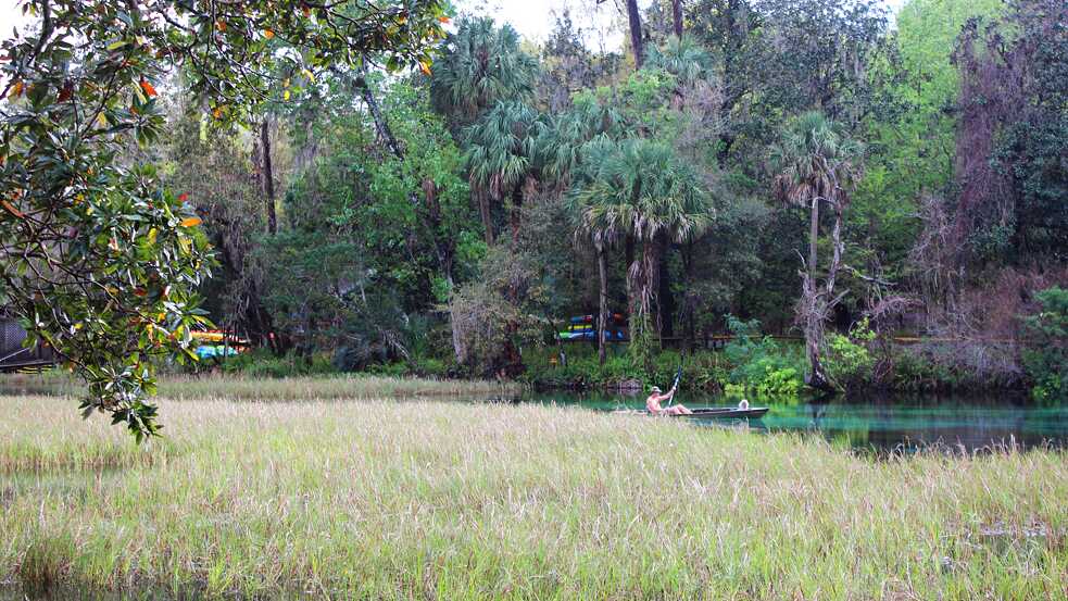 A man canoes through the turquoise waters of Rainbow Springs