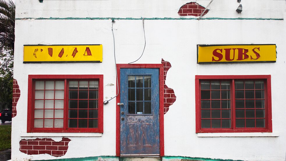 La fachada de un restaurante abandonado que vendía pizza y sándwiches