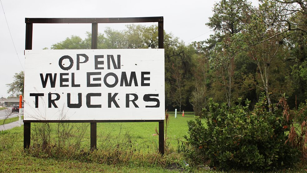 A sign reading “open welcome truckrs” 