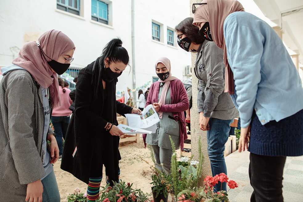 Cinq jeunes élèves sélectionnent des plantes regroupées au milieu.