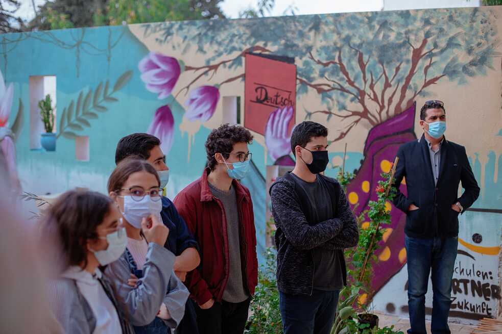 Les élèves sont debout devant un graffiti.