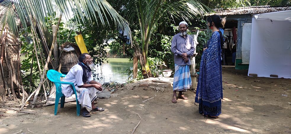 Elem Miah (mittig) und Mahenaz Mahenaz Chowdhury (rechts) im Hinterhof zwischen der Weberei und Miahs Wohnsitz