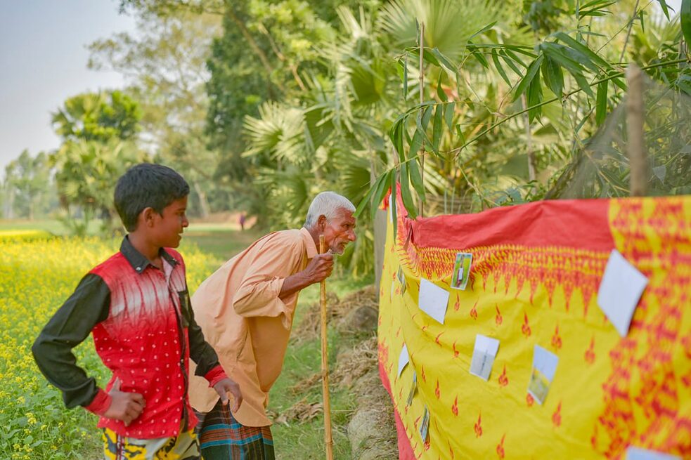  Ein Workshop-Teilnehmer teilt seine Erfahrungen mit einem Besucher
