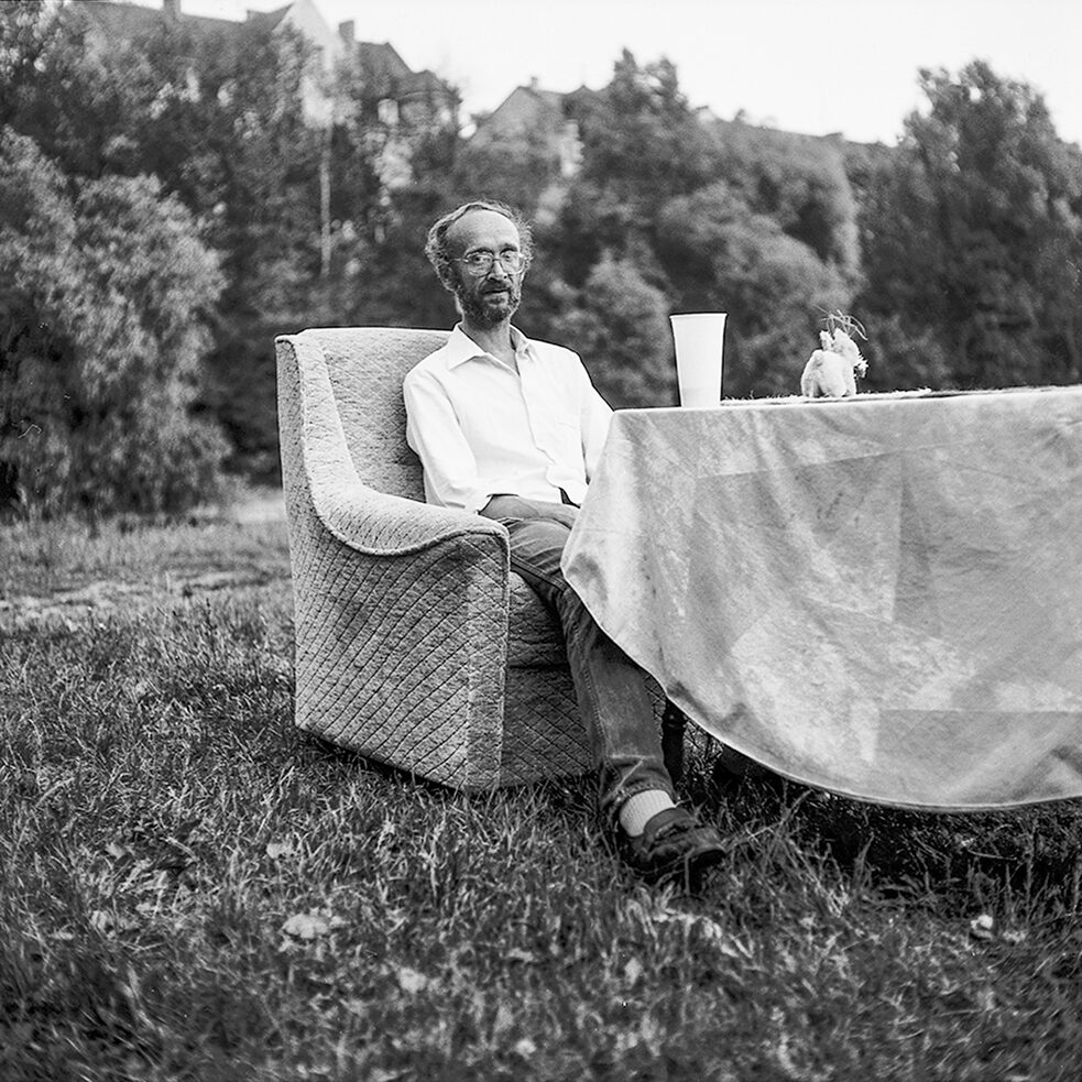 Ein Mann sitzt an einem Tisch im Englischen Garten in München