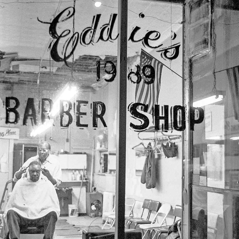 A man getting a haircut at Eddie’s Haircut & Shave, a barber shop in Harlem, New York