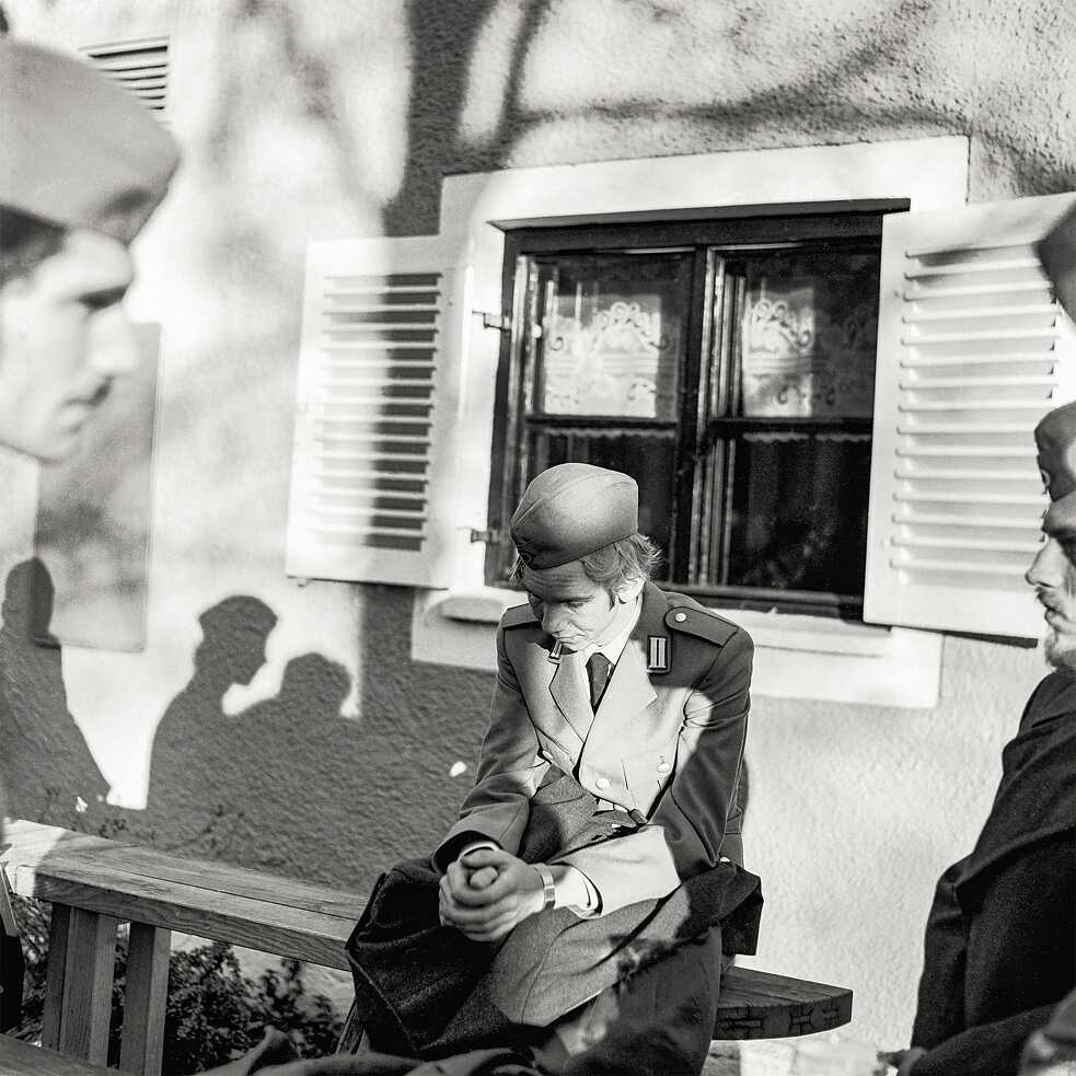 A soldier sitting on a bench outside