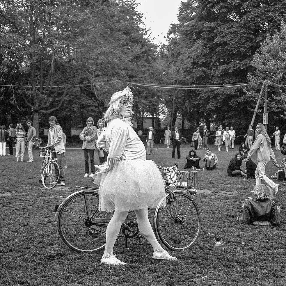 A man in costume walks his bicycle through Munich’s English Garden 
