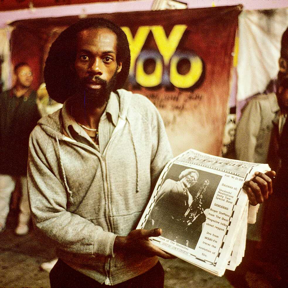 A vendor selling newspapers outside of the Apollo Theater in Harlem, New York