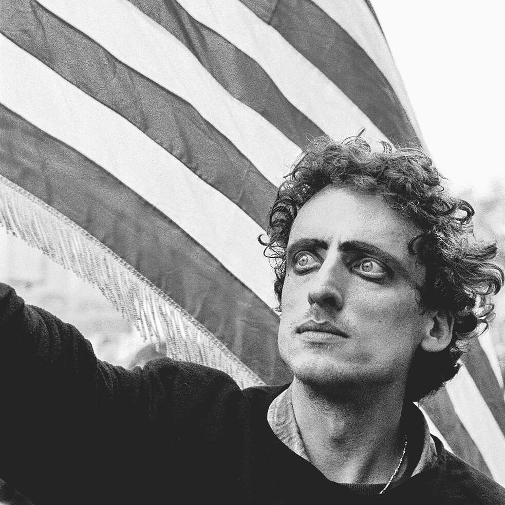 A man holding an American flag at a protest