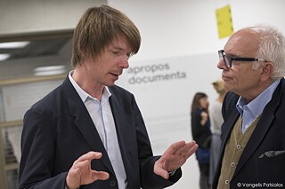 Ο Adam Szymczyk, καλλιτεχνικός διευθυντής της documenta 14 μαζί με το Ντένη Ζαχαρόπουλο, ιστορικό τέχνης στα εγκαίνια της έκθεσης „apropos documenta“. Η documenta 14 πραγματοποιήθηκε το 2017 παράλληλα στο Kassel και την Αθήνα.  Το „apropos documenta“ παρουσίασε υλικό από τις προηγούμενες διοργανώσεις (1955-2012).