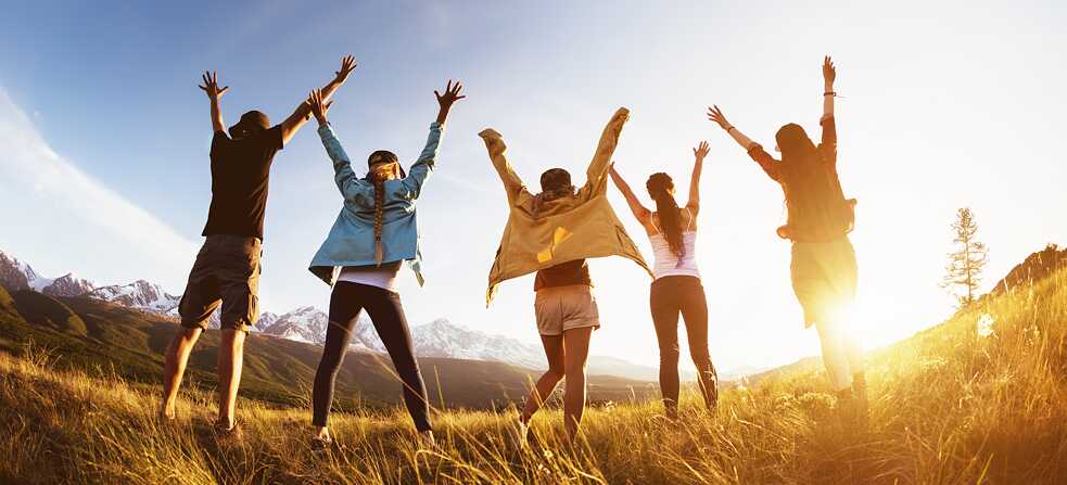 Gruppe von jungen Leuten mit erhobenen Armen