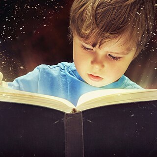 Junge liest aus einem Buch 