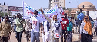 Amna Bihiry führt am 30. September 2021 einen Protest in Khartum an und zeigt das Foto ihres Sohnes Kisha Abdelsalam.