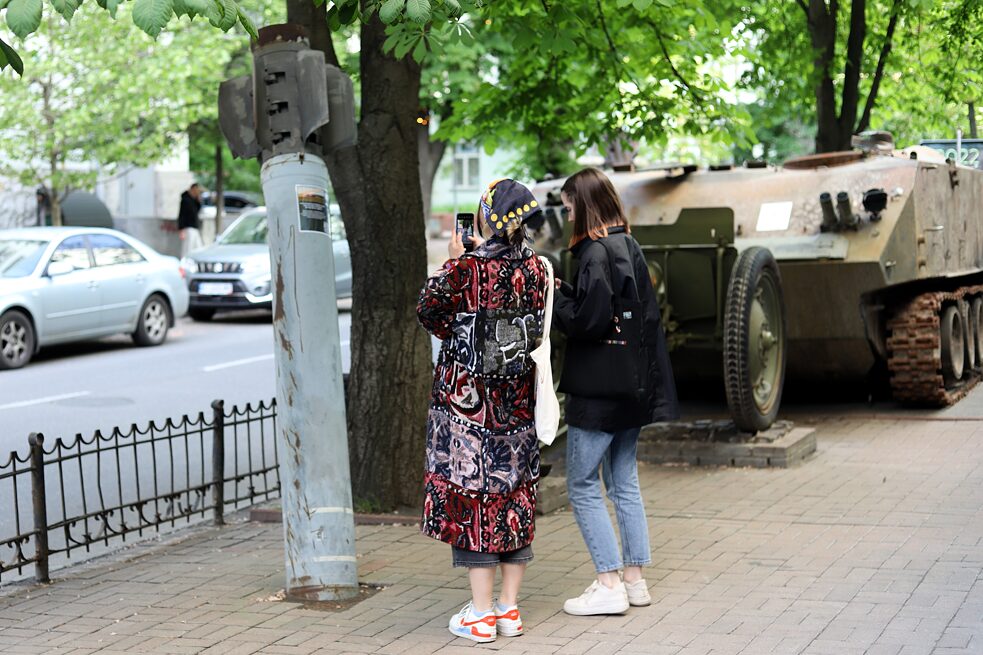 Zwei junge Frauen fotografieren eine russische BM-30-„Smertsch”-Rakete, die am 3. September 2014 auf ein Dorf im Luhansker Gebiet abgefeuert wurde und nun in einer Straßenausstellung mit zerstörter russischer Kriegstechnik in der Kyjiwer Innenstadt ausgestellt ist.