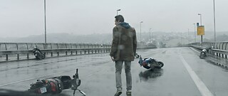 Mann auf leerer Straße, auf der Motorräder liegen