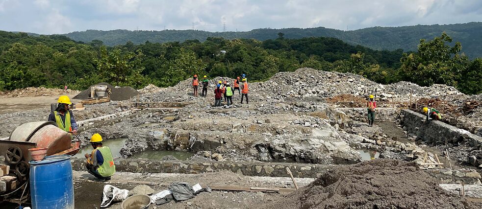Die Vorbereitungsarbeiten für den dreistöckigen Bau laufen bereits auf Hochtouren. Verwendet werden Steine aus gepresstem Plastik, die sich aus einem Müllberg in nur etwa 200 Meter Entfernung speisen.
