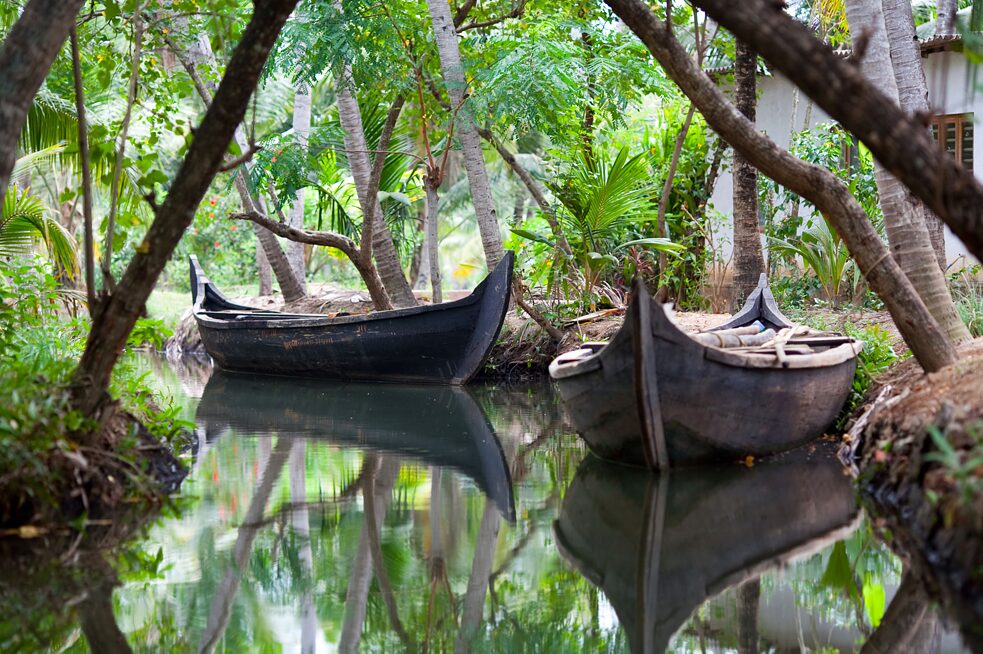 Backwaters in Kerala: Kerala ist ein beliebtes Reiseziel in Südindien. In der Hochsaison wimmelt es von einheimischen und ausländischen Touristen. Vor allem durch die malerischen Backwaters schippert ein Hausboot hinter dem anderen. Sobald der Monsun und mit ihm das kühlere Wetter einsetzt, kehren Stille und Geruhsamkeit ein. Sie lösen das quirlige Treiben auf dem Wasser ab. Ruhe senkt sich über die Seen, Kanäle und Lagunen. Kähne dümpeln gemütlich in einem Dschungel aus Palmwäldern, Reisfeldern oder einfach undurchdringlichem Buschwerk und freuen sich über ihre wohlverdiente Pause. Die Natur übernimmt das Ruder. In der Nebensaison schimmert sie in Kerala übrigens besonders bezaubernd.