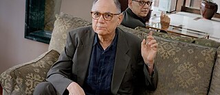 Hombre con lentes sentado en un sofá 